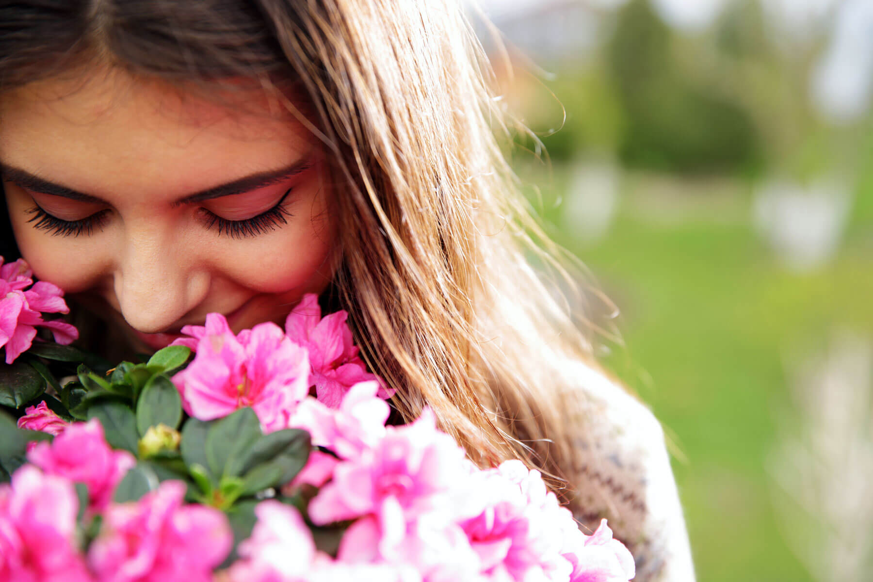 woman smelling pink flowers